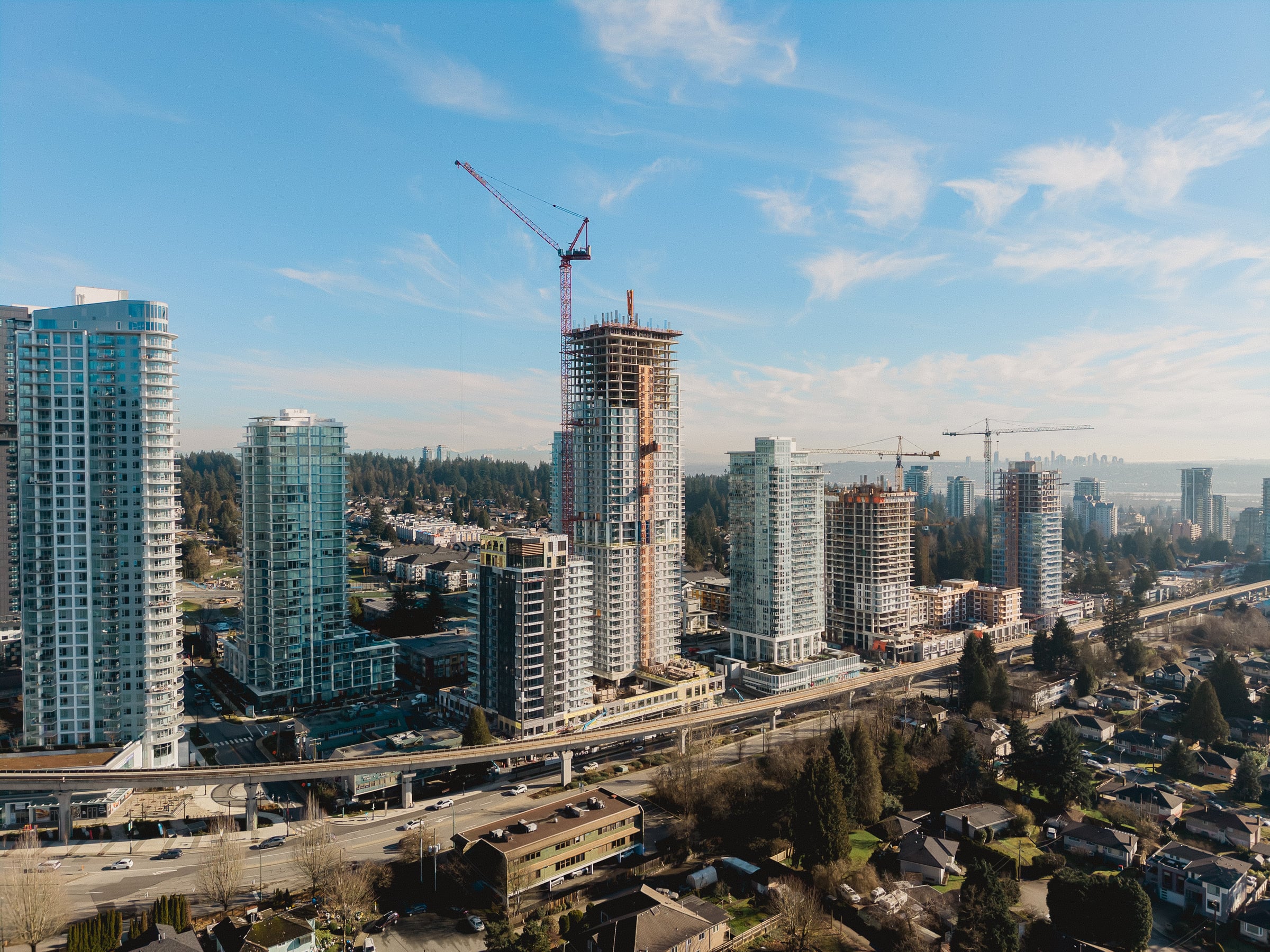 West Coquitlam from above, with the SkyTrain line and the tower under construction
